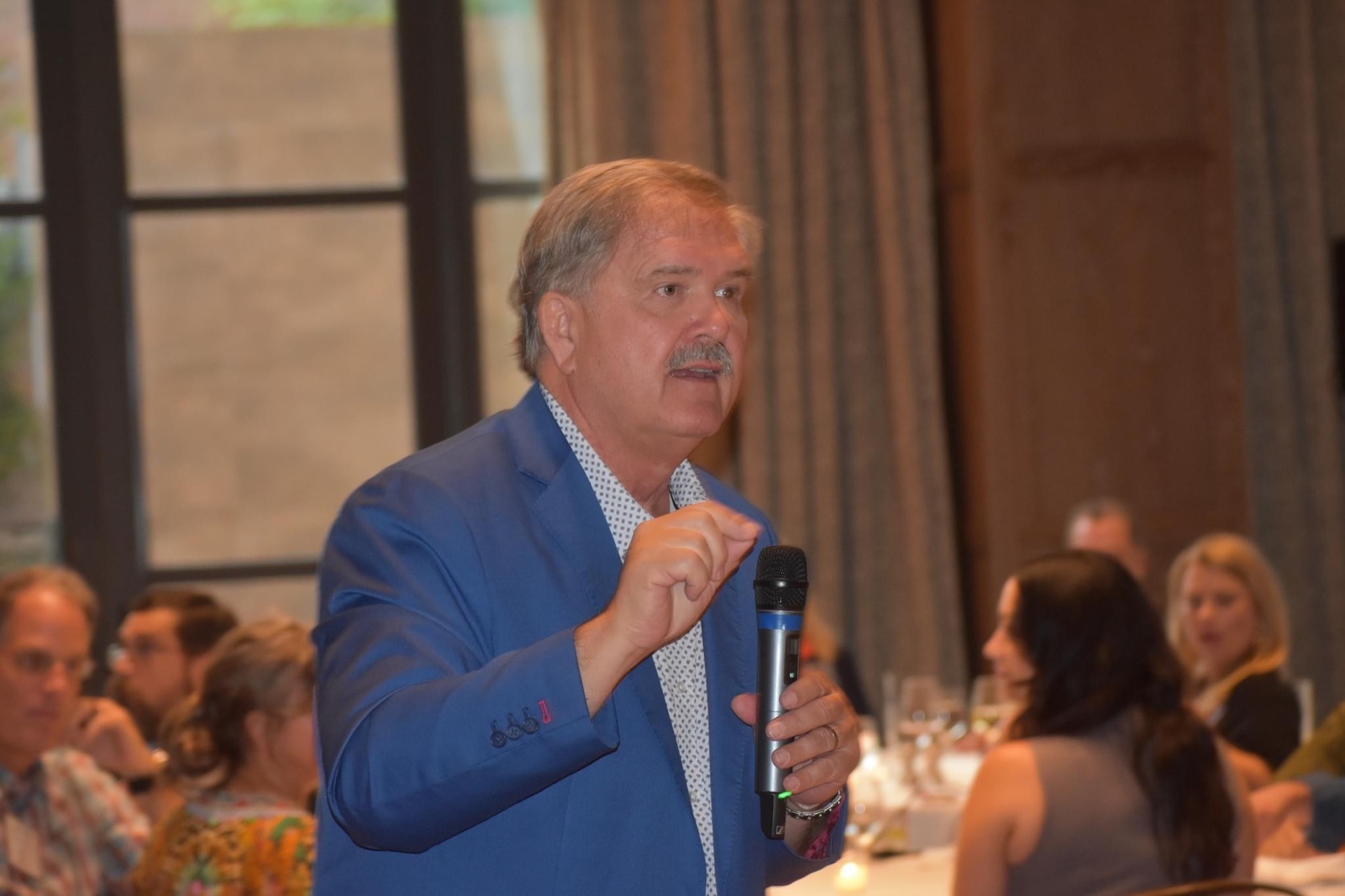 Don Williams speaking on stage at a leadership conference